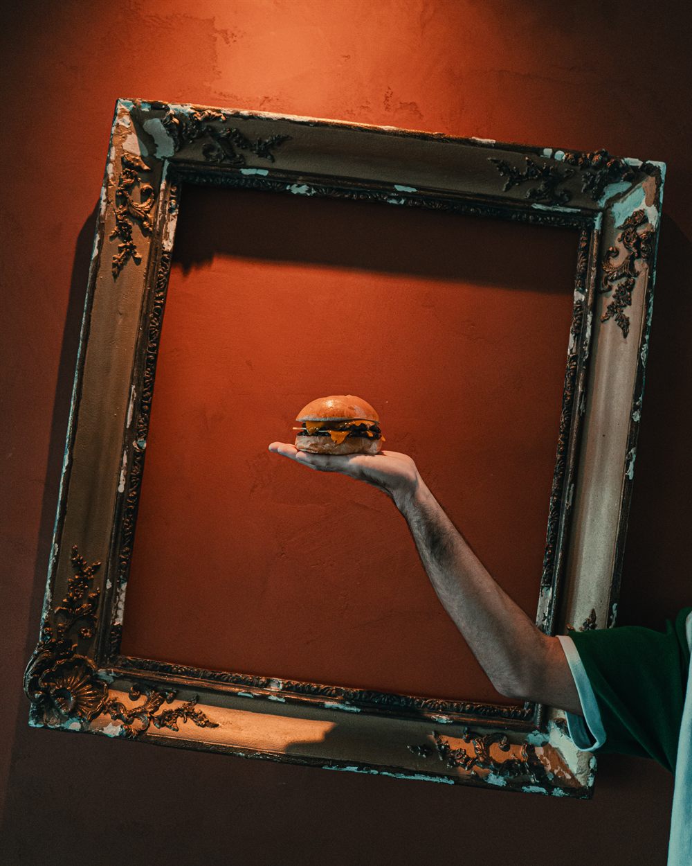 Burger Amann! présenté dans un cadre doré sur un mur terracotta