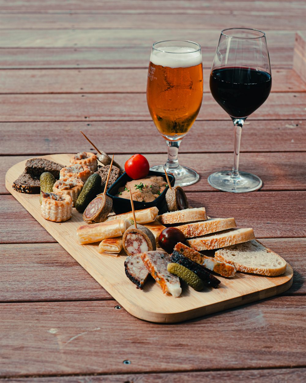 Planche de charcuterie Amann! servie avec une bière et un verre de vin rouge